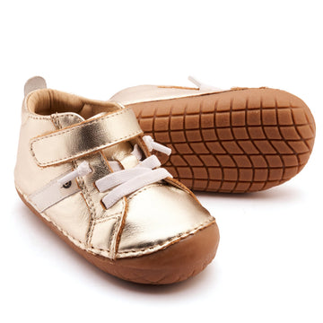 Gold baby shoes on a white background