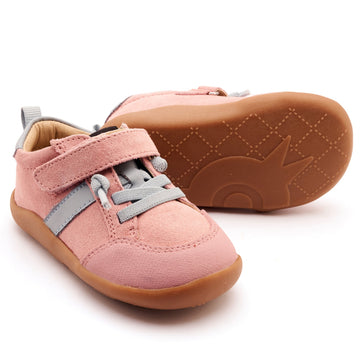 Pink children's shoes with brown soles on a white background